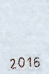 Text 2016 written on snow with wood background. Vertical holiday top view postcard with space for copy or lettering.
