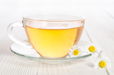 Cup of medicinal chamomile tea  on the wooden table