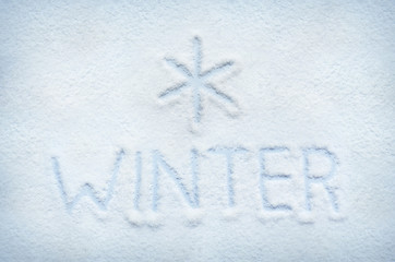 Text WINTER written on snow and snowflake sign mark. Horizontal postcard.