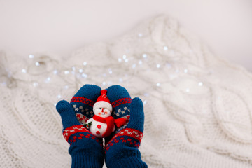 Female hands holding a cute happy Snowman