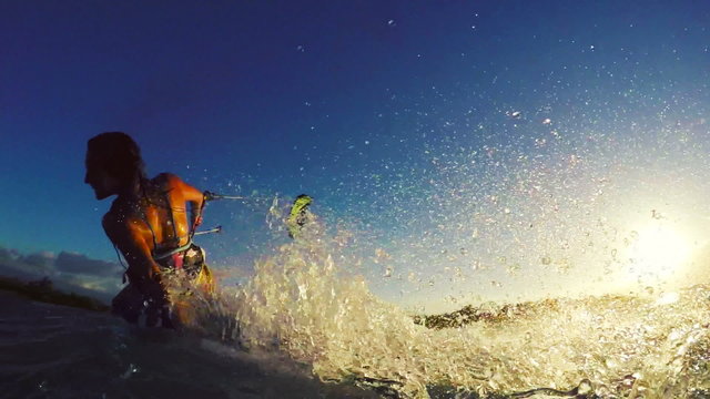 Extreme Kitesurfing at Sunset. Summer Ocean Sport in Slow Motion. Girl Kite Surfing in Bikini 