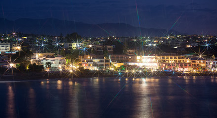 Night view of beach with houses.