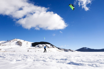 The snowkiting is sliding on the snow-covered valley