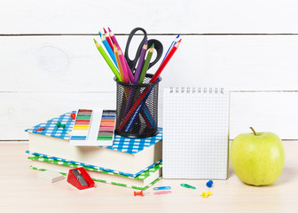 Group of school supplies and books over a white background