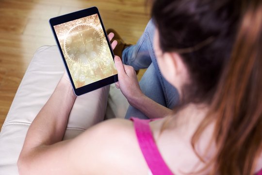 Composite image of woman using tablet at home