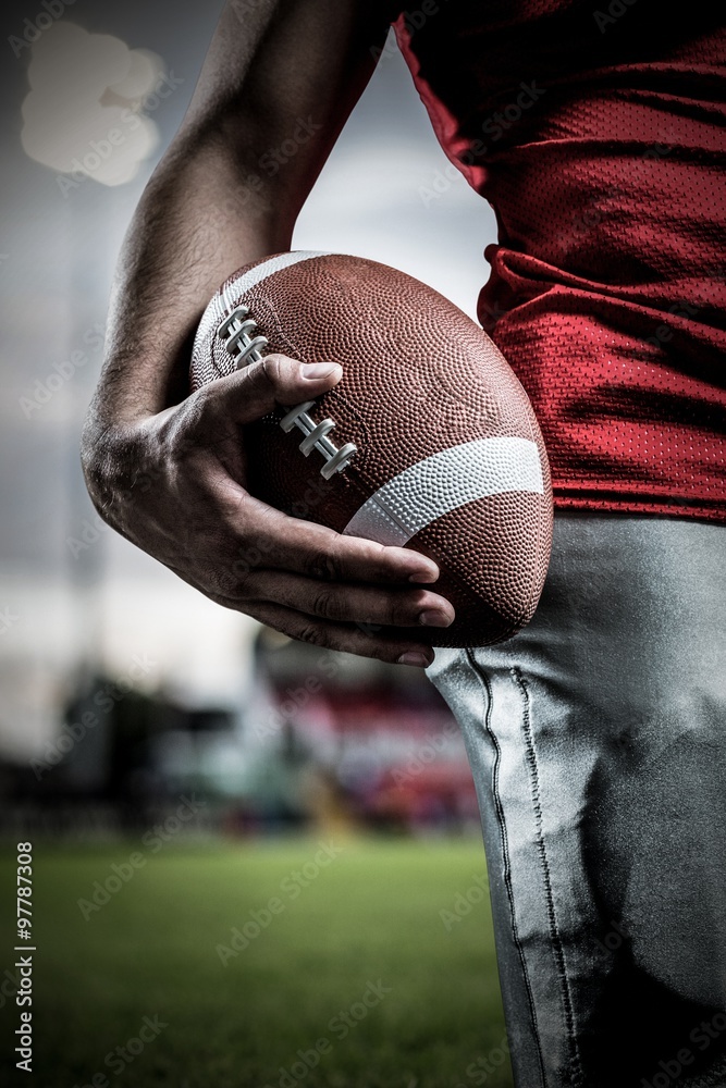 Canvas Prints Composite image of sportsman holding american football ball