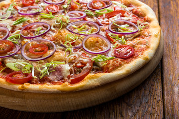 Delicious pizza with onions, bacon and cherry tomato