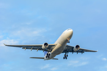 Airplane is flying to the runway from the airport during a cloudy day.