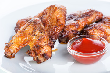Crispy fried chicken wings with ketchup on a white background