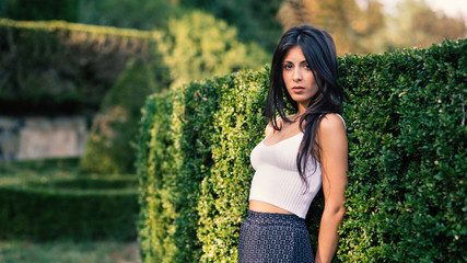 Close up young brunette woman portrait outdoors in a park. Filte