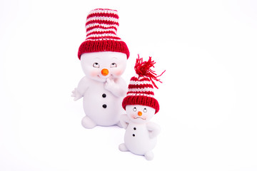 Два белых снеговика в шапках на белом фоне
