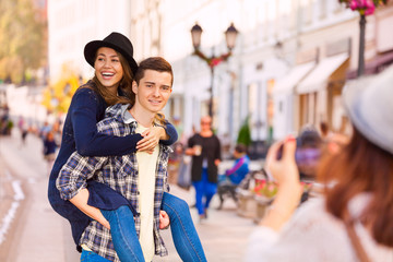 Boy carrying laughing woman and girl shooting them
