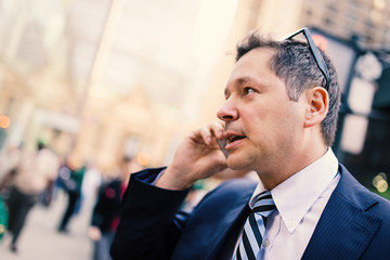 Businessman talking at the phone on the street. Manhattan, New York.