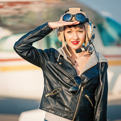 Young woman airplane pilot portrait on landing strip. Filtered i
