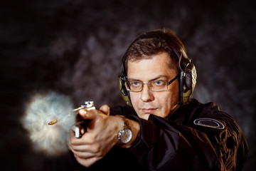 Closeup portrait of man with gun making shot at training club 