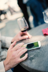 Detail of young woman using smartphone in a cafe in Paris, France.