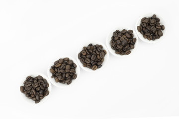 Coffee beans in white bowl on white background isolated