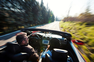 Young couple portrait on cabriolet sportscar in a sunny day. 