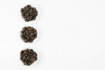 Coffee beans in white bowl on white background isolated