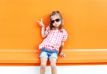 Fashion stylish little girl child wearing a sunglasses and check