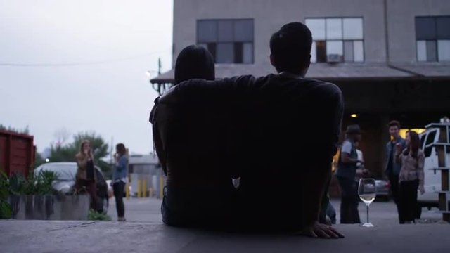 Couple drinking and watching friends leave as party slowly winds down to an end
