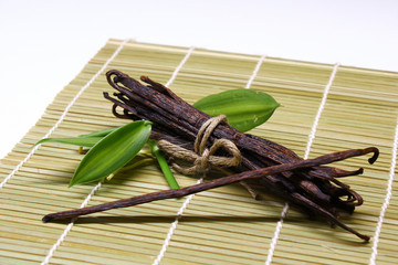vanilla beans with leaf on bamboo background