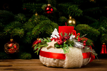 Christmas decoration - christmas wreath and coniferous branch on the wooden background.