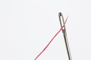 hand sewing needle with red thread bobbin
