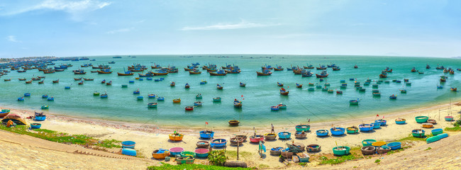 Panorama boating fishing village with basket boats, fishing boats moored on coastline while watching the boats lined wood as spread of  popular fishing village in Vietnam