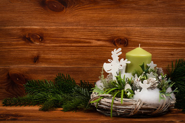 Christmas decoration - christmas wreath and coniferous branch on the wooden background.