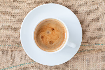 Cup of hot coffee on brown fabric