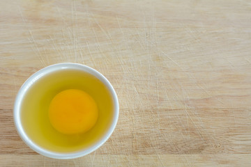 Fototapeta na wymiar Fresh Egg With Bowl of Egg White on Wooden Table, Food Rustic Style.