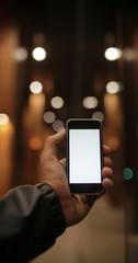 Man hand hold blank touch screen smart phone on abstract blurred