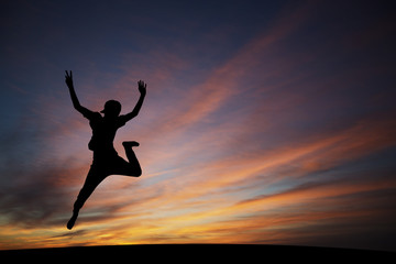 silhouetted boy jumping in sunset for fun