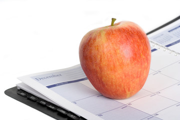 An Apple on a Day Planner – An apple sitting on a day planner.