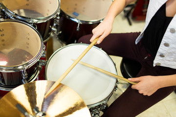 close up of musician playing cymbals on drum kit