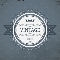 Round vintage label with ribbon, royal crown and grunge background. Vector illustration.