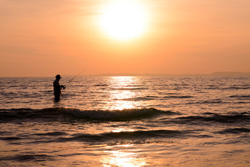 Obraz premium Silhouette angler sunset background.