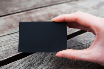 Hand holding a black business or visit card