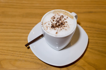 Coffee, cappuccino, hot on the wooden table.