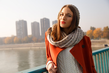 Obraz premium Portrait of a beautiful young brunette woman on the bridge, she is looking at camera.