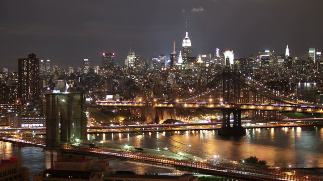 Time Lapse Nightscape of the Brooklyn Bridge and the Manhattan Bridge in front of Manhattan.