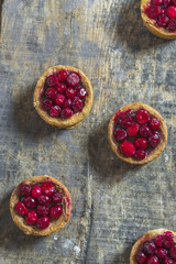 Traditional pork pies with cranberry topping on a wooden board - top view