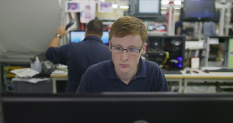 Male worker in an electronics factory working on computer testing and repairs