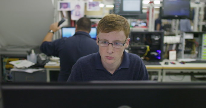 Male worker in an electronics factory working on computer testing and repairs