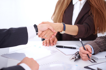 Business handshak  sitting at the desk on office background, copy space area at the left upper corner