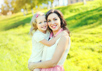 happy smiling mother hugging child daughter in summer day