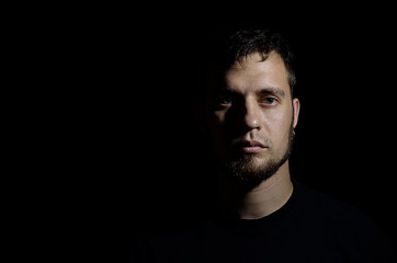 Fototapeta premium Portrait of a man with a beard against a black background.