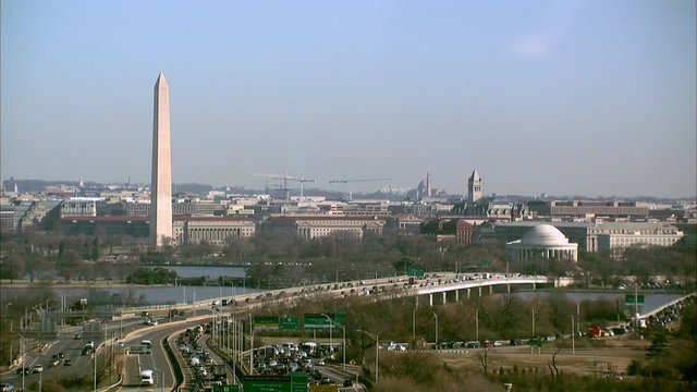 Airplane Flies by the Washington Monument, Jefferson Memorial and traffic in Washington, D.C.