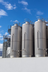 Giant industrial tanks on the bright blue sky